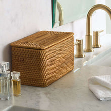 Brown rattan organizer basket with closed lid on countertop, woven basket sides.