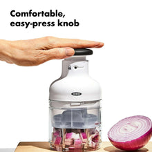 White food chopper with easy-press knob and clear bowl, onion pieces inside