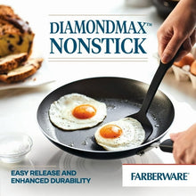 Nonstick skillet with two fried eggs and black spatula