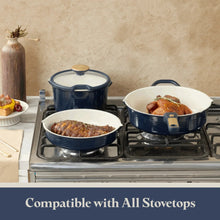 Blue ceramic cookware on a stovetop: pot and pans with lids and handles.