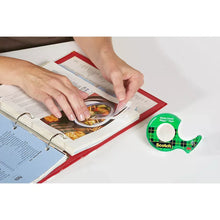 Transparent tape being applied from Scotch Magic Tape dispenser to a binder