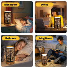 Table lamp with black cylindrical branch-pattern shade and wooden base in bedroom and office scenes.