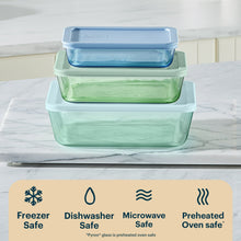 Stacked tinted rectangular plastic food storage containers with blue and green lids