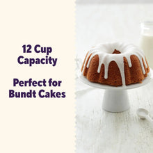 Bundt cake with white icing drips on a fluted cake stand