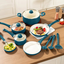 Blue ceramic nonstick pots and pans with cream lids and utensils arranged for cooking