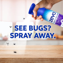 Hand holding Zevo insect killer spray bottle with blue nozzle