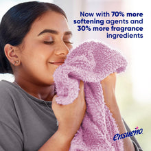 Fabric softener bottle beside a person holding a plush purple towel, Spring Fresh
