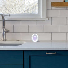 Plug-in air freshener device sitting on a countertop near a sink