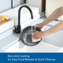 Gray round cake pan being washed under a faucet