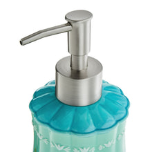 Stainless steel soap dispenser pump on teal stoneware, floral band
