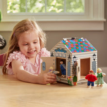 Wooden take-along dollhouse with child holding a poseable doll