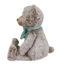 Plush bear seated in profile, teal bow scarf, tan muzzle and light gray paws