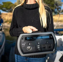 Portable power station held outdoors, showing screen, 12V and USB ports