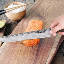 Slicer knife with patterned steel blade being used to cut salmon on a board