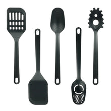 Black silicone-style cooking utensils, including spatulas, whisk, and meat-tenderizer tool