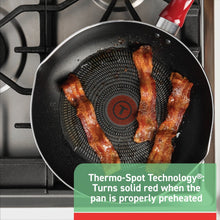 Red nonstick frying pan with black interior, bacon cooking