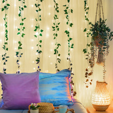 LED vine curtain lights with green leaves and warm white glow above bedding