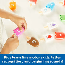 Kid hands playing with colorful alphabet letter pop toys on a flat surface