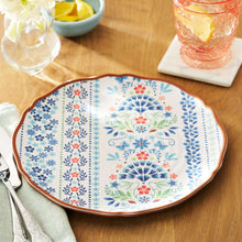 Floral dinner plate with blue and red blossoms, brown scalloped rim.