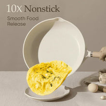 White nonstick skillet with wooden handle, holding an omelet