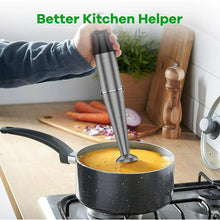 Immersion blender in a saucepan, stainless steel shaft with black motor housing