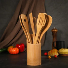 Wooden utensil set in cylindrical bamboo holder with assorted spatulas and spoon