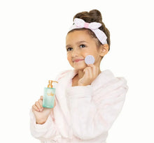Children's white bath robe with pink bow headband, holding a spa bottle