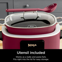 Cherry tarte multi-cooker with glass lid and red utensil resting on lid handle