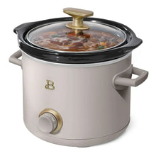 Manual slow cooker with glass lid, gold knob, light gray pot and black base