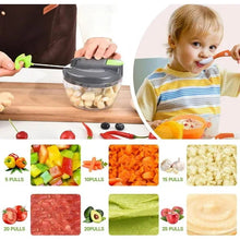 Manual food chopper on table with clear bowl and green lid, ready for chopping