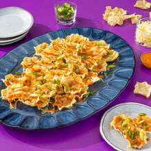 Tostitos Scoops! tortilla chips on blue plate with shredded toppings