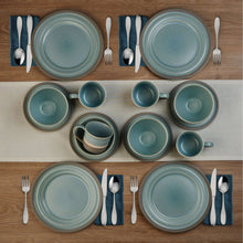 Stoneware dinnerware set layout: plates, bowls, and mugs in blue tones.