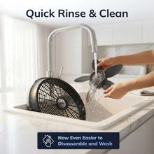 Black floor fan near sink with water spray, ready for cleaning