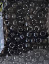 Close-up of black plastic pony beads with center holes