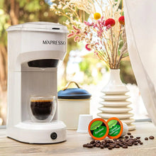 White single-serve coffee brewer with brewing chamber and coffee cup, pods and beans