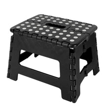 Black plastic foldable step stool with white polka dot top and grip handle