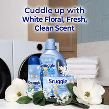 Snuggle Blue Sparkle scent booster bottles on display with white flowers