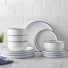 Stoneware dinnerware set with blue rims: stacked bowls and plates