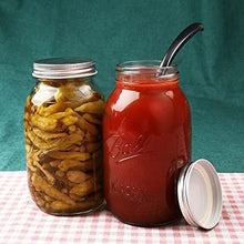 Wide-mouth glass mason jars with metal lids and bands, one with pickles and one with drink