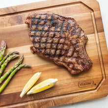 Acacia carving board with grilled steak, asparagus, and VIKING juice groove