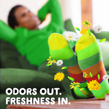 Green liquid laundry detergent bottle beside a person holding green towels