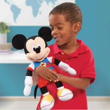 Singing Mickey Mouse plush toy hugged by child, blue shirt and red shorts