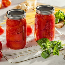 Wide-mouth glass mason jars with metal lids and bands, filled with red preserves