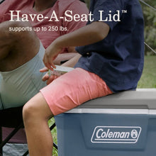 Blue hard cooler with open lid, showing interior storage for food and drinks.