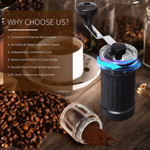 Black portable coffee grinder with crank handle and clear grounds container on table