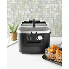 Electric deep fryer with stainless lid and basket holding golden fried food