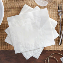 Stack of white 3-ply paper napkins on a burlap table runner