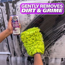 Wheel cleaner spray bottle and neon green microfiber wash mitt on a wheel surface