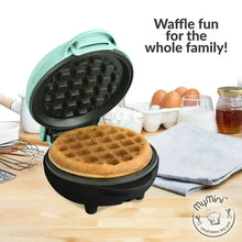 Teal mini waffle maker open with square waffle plates and a cooked waffle