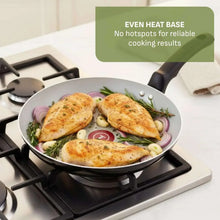 Black ceramic non-stick sauté pan on stove with two handles and poultry inside